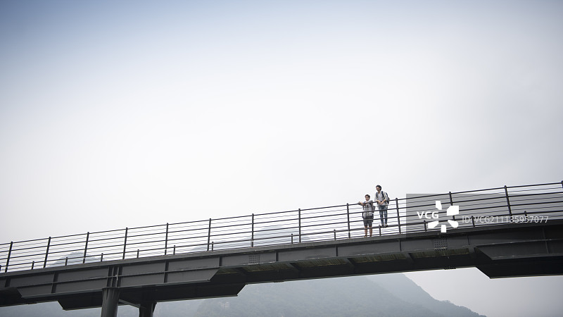 两名旅行者站在昭阳湖桥上的广角图图片素材