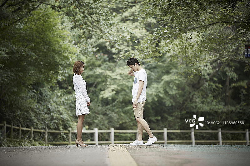 公园情侣侧面像，男子走向女友图片素材