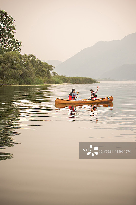 幸福家庭在山间河流中划独木舟图片素材