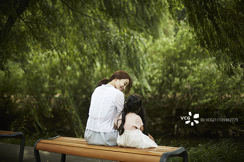 在公园长椅上休息的母女摄影图片素材