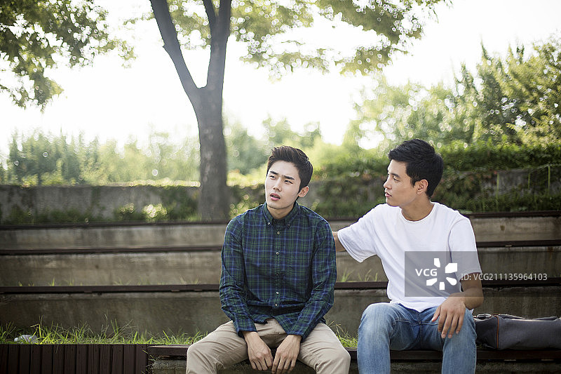 穿着休闲装坐在长椅上的男人照片图片素材