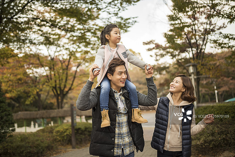 秋日公园里父亲扛着女儿的温馨家庭摄影图片素材