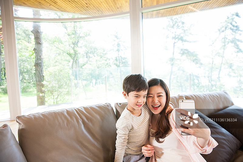 猴妈妈和儿子们在沙发上看电视图片素材