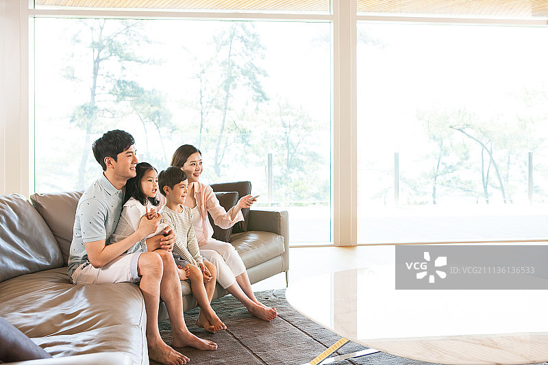 一家人坐在沙发上看电视图片素材