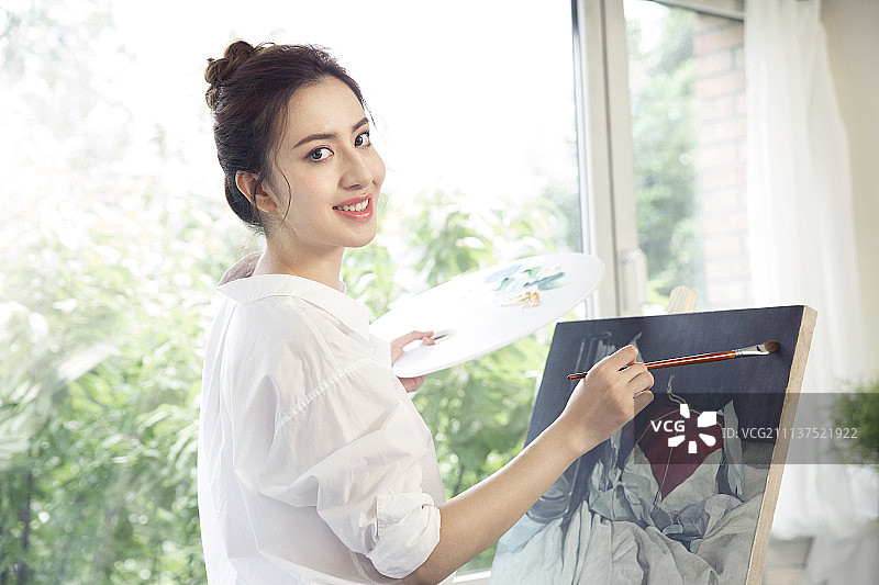 年轻女子在画室画画图片素材