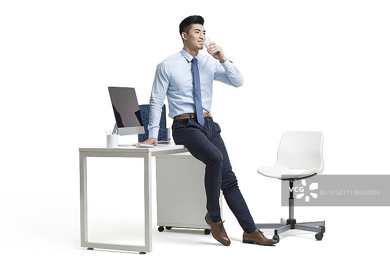 年轻商务男士在办公室喝牛奶图片素材