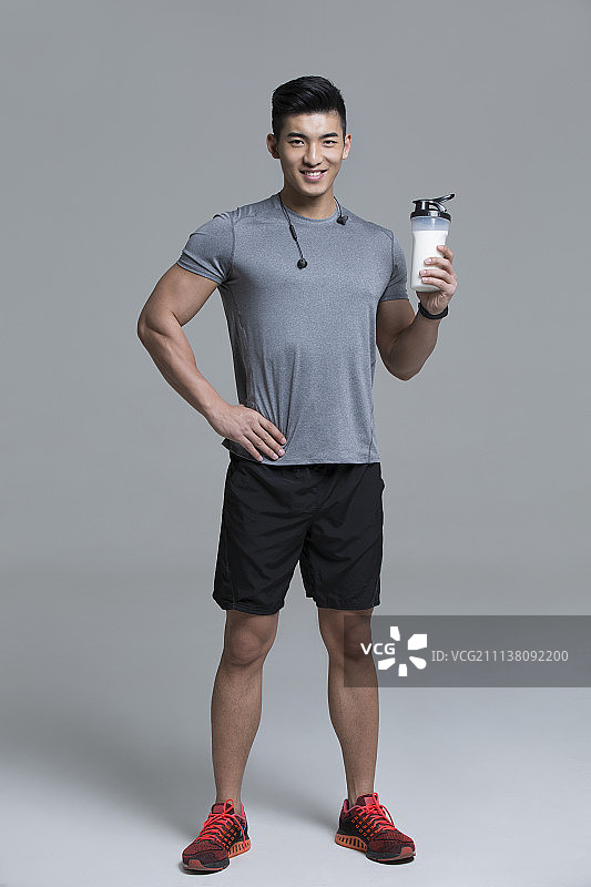 男运动员手拿一瓶牛奶图片素材