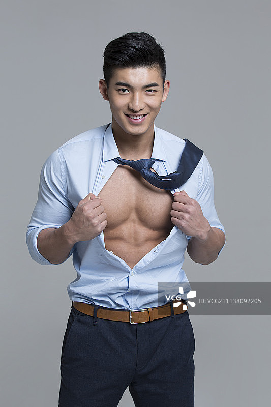 年轻商务男子展示肌肉图片素材