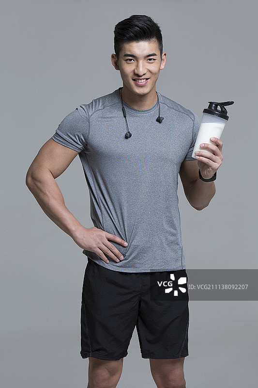 男运动员手拿一瓶牛奶图片素材