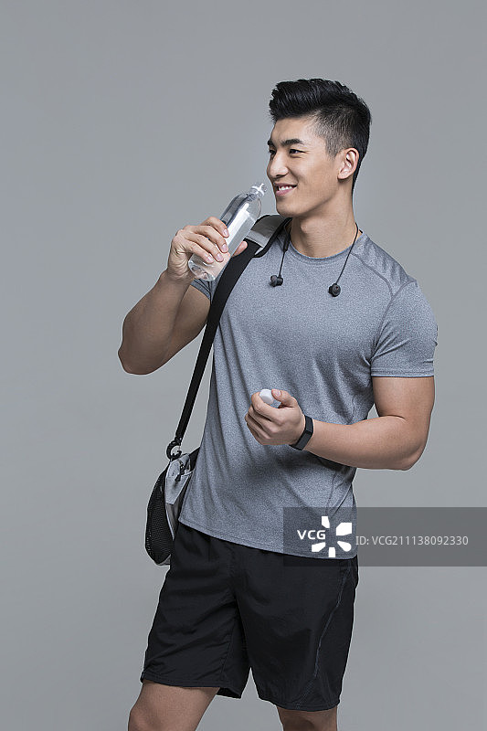 快乐的男运动员在喝水图片素材