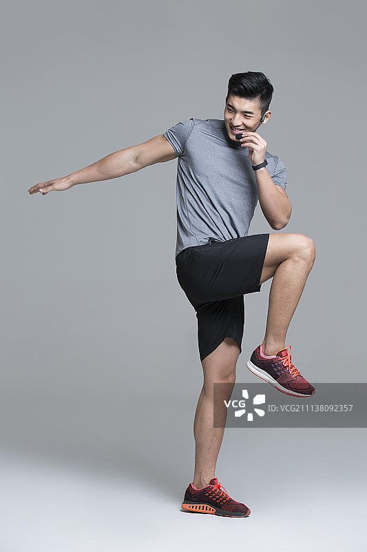 佩戴耳麦的快乐男教练在健身房授课图片素材