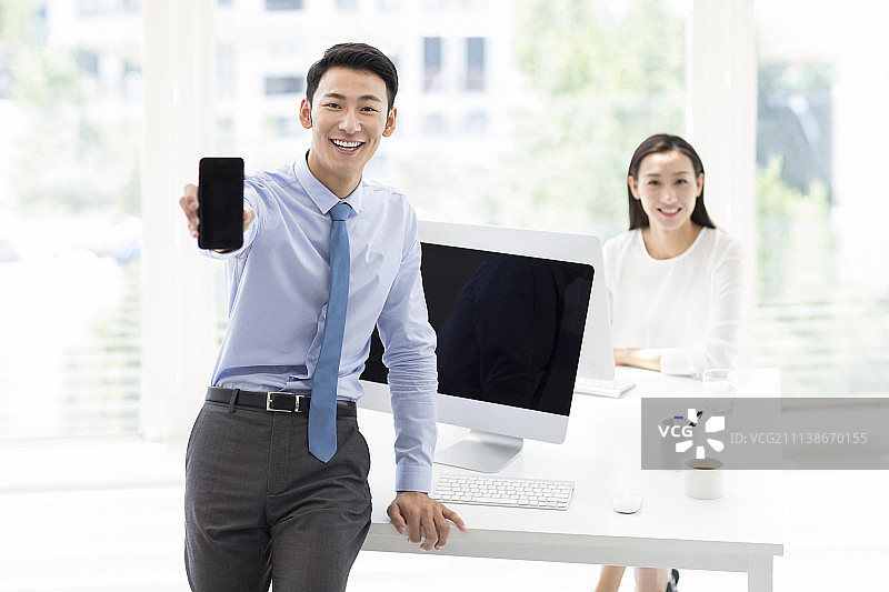 年轻商务男士在办公室展示手机图片素材