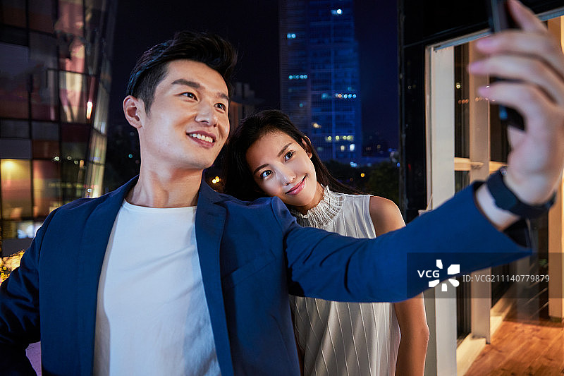 青年情侣用手机拍照图片素材