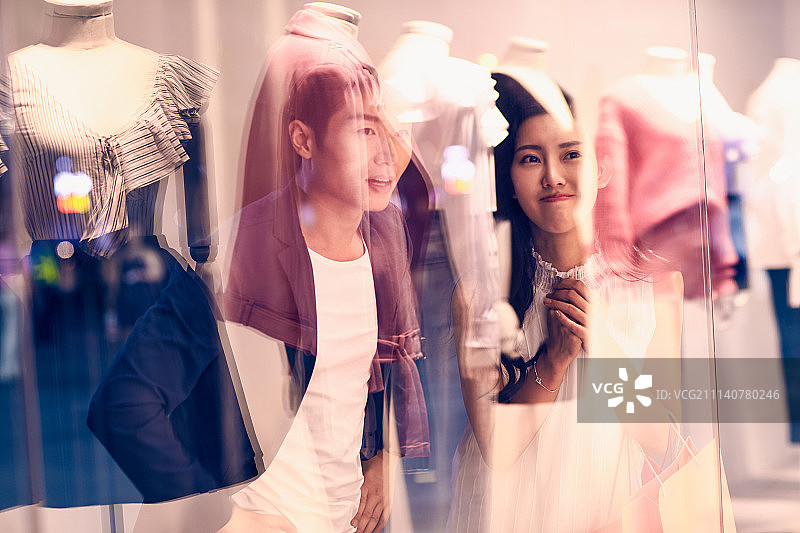 青年情侣在服装店挑选衣服图片素材