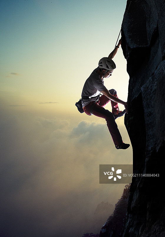 中年男人悬崖上攀岩图片素材