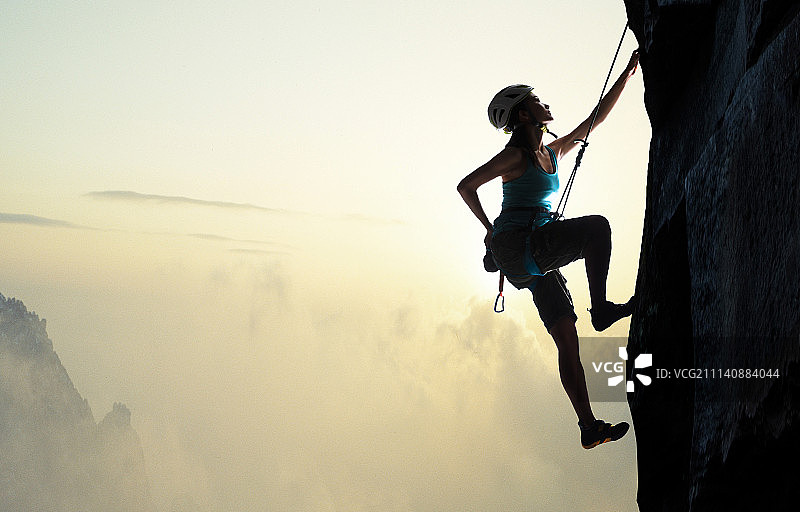 青年女人悬崖上攀岩图片素材