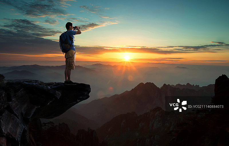 中年男人站在悬崖上远眺图片素材