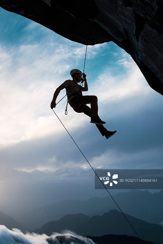 中年男人悬崖上攀岩图片素材