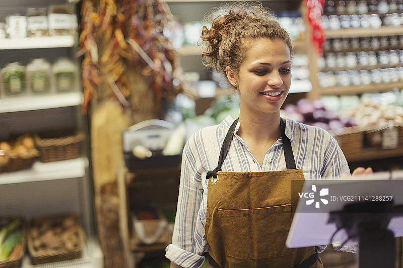 女收银员在杂货店使用触摸屏收银机图片素材