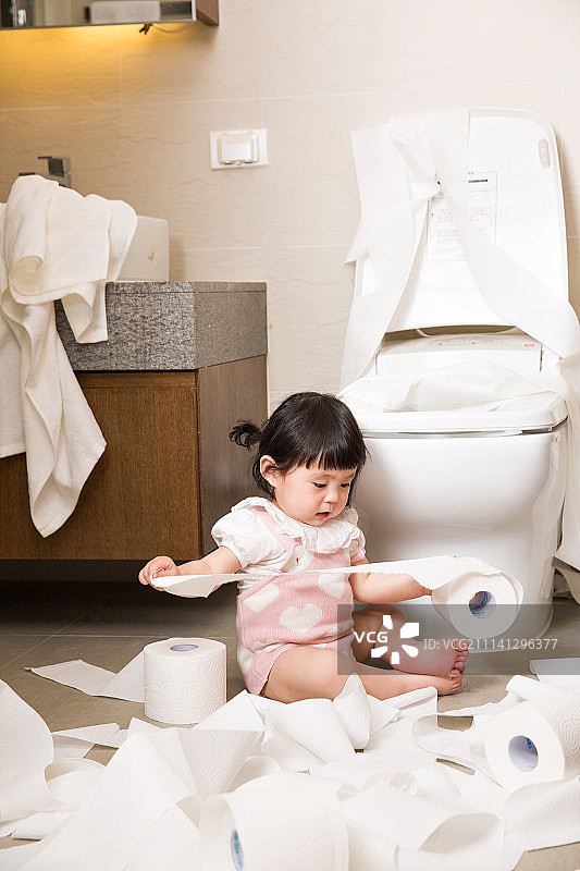 小女孩在浴室里玩卫生纸图片素材