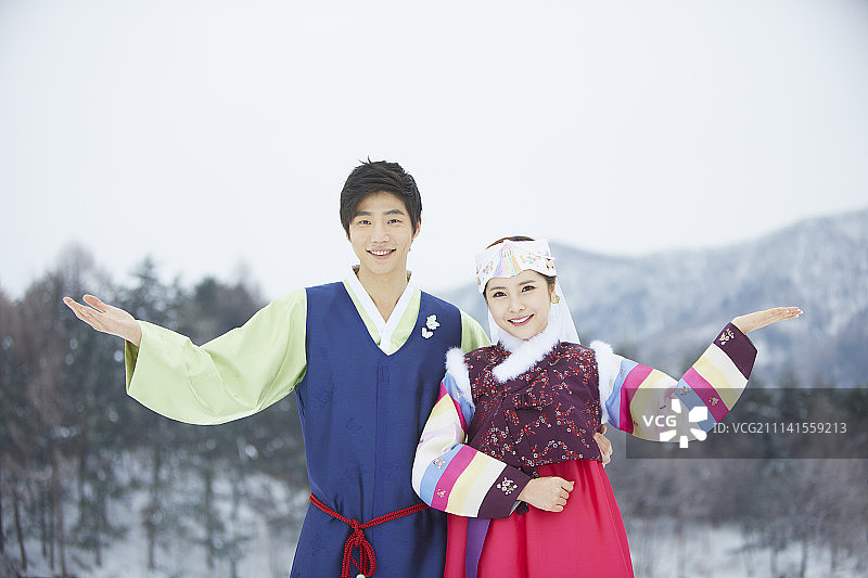 情侣身穿韩服站在雪地上迎接的摄影照片图片素材