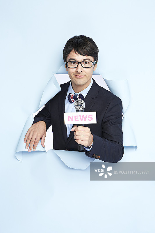 新闻播音员在蓝色背景前的影棚拍摄图片素材