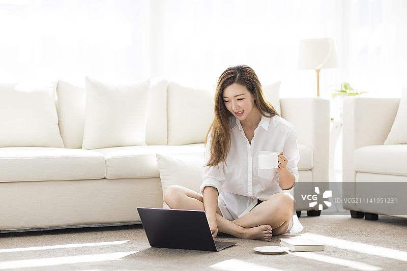 年轻女子在家使用笔记本电脑图片素材