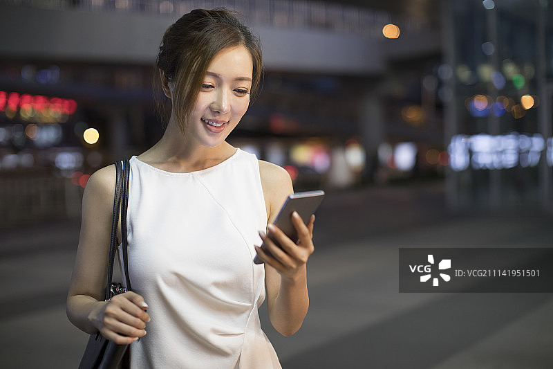 开心的年轻商务女子使用手机图片素材
