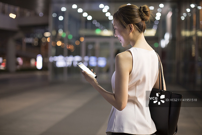 开心的年轻商务女子使用手机图片素材