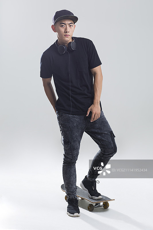 戴耳机的年轻男子在滑滑板图片素材