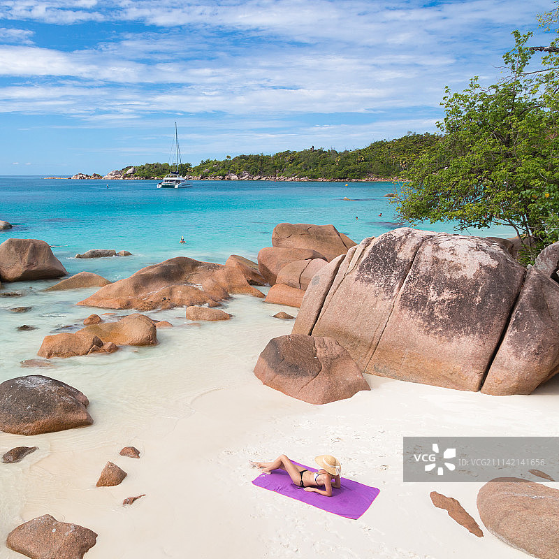 在塞舌尔普拉兰岛Anse Lazio海滩上享受日光浴的女人图片素材