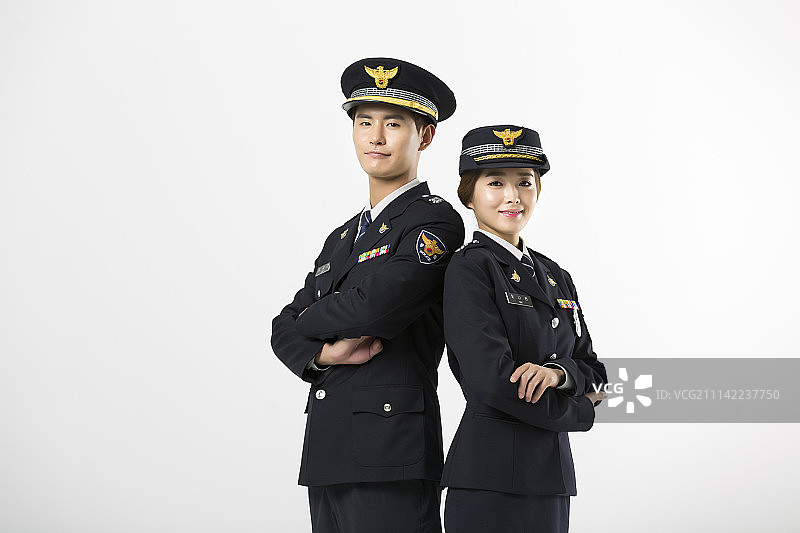 穿着警官制服的男人和女人双臂交叉背靠背站立图片素材
