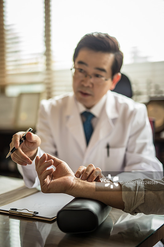 东方医学诊所的医生为病人诊断脉搏图片素材