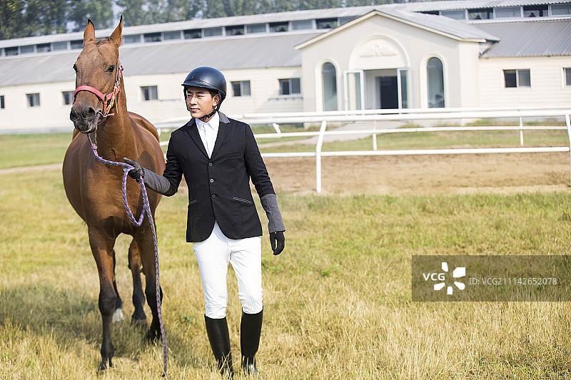 马术运动员牵着马行走图片素材