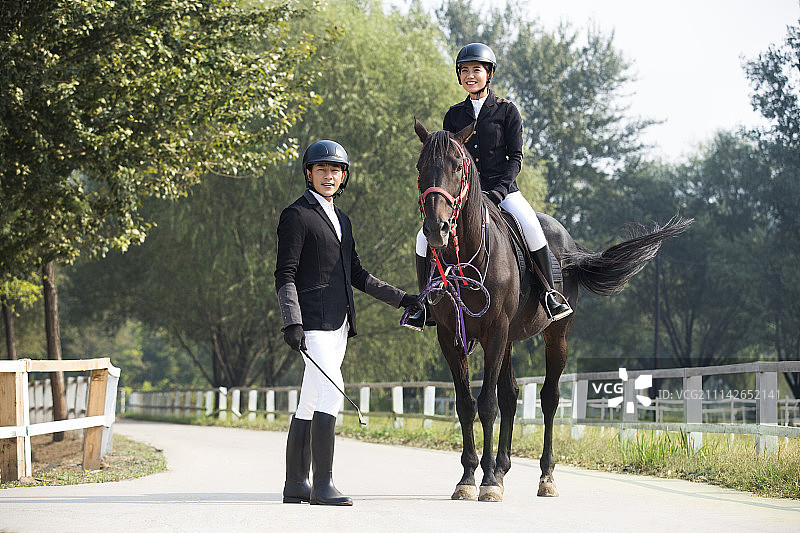 年轻情侣在马场骑马图片素材