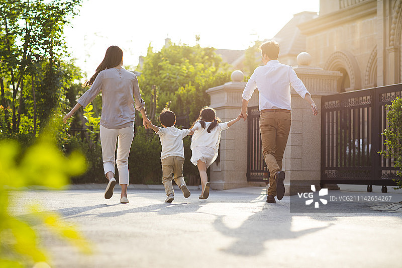快乐的年轻家庭手牵手奔跑图片素材