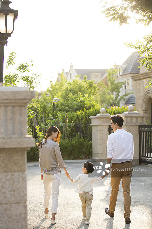 快乐的年轻家庭手牵手散步图片素材