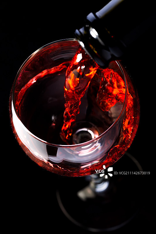 黑色背景下的葡萄酒瓶和酒杯图片素材