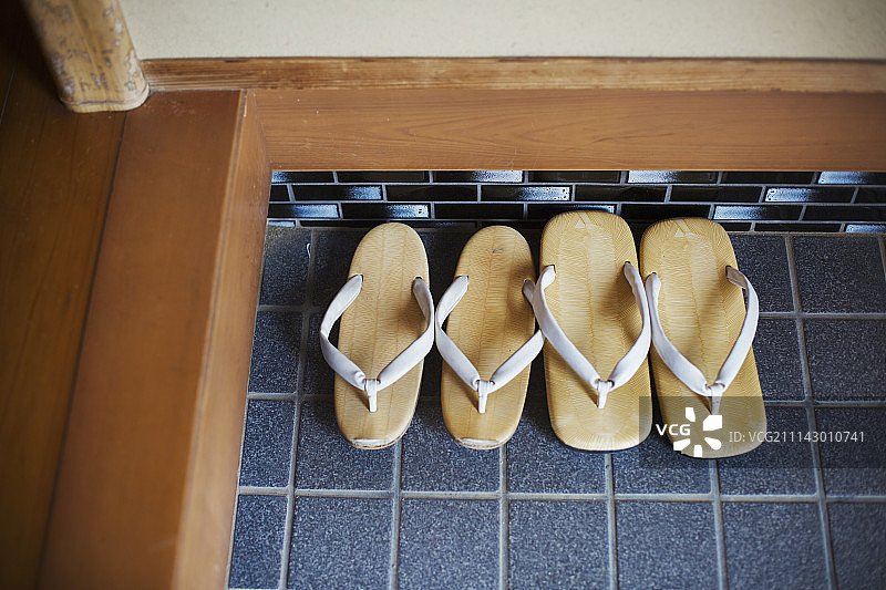 蓝色瓷砖地板上的两双日式传统凉鞋图片素材