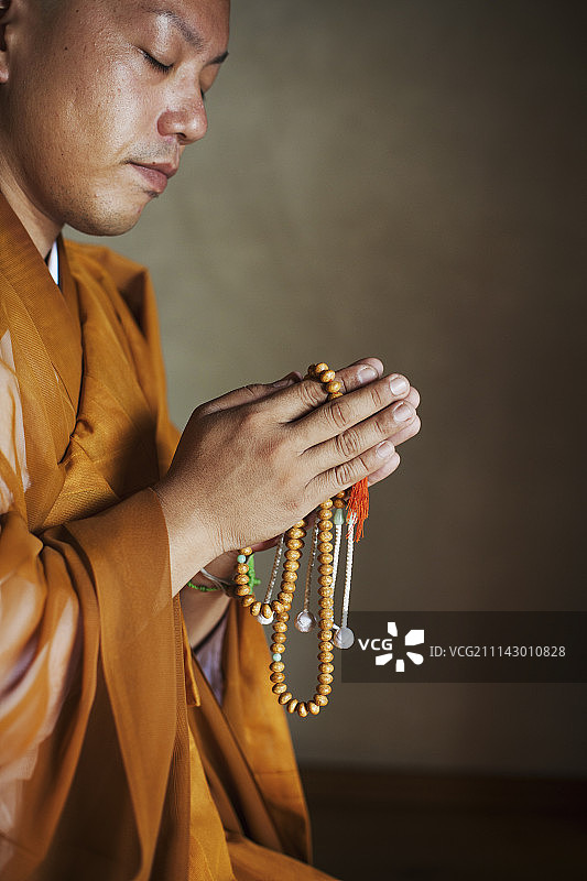 在寺庙内跪着祈祷的僧侣侧视图图片素材