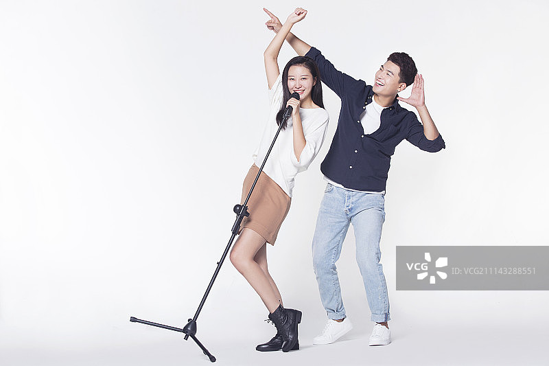快乐情侣拿着麦克风唱歌图片素材