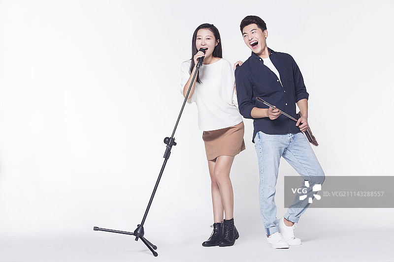 快乐情侣拿着麦克风唱歌图片素材