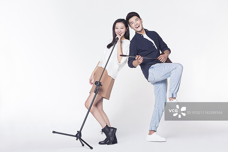 快乐情侣拿着麦克风唱歌图片素材