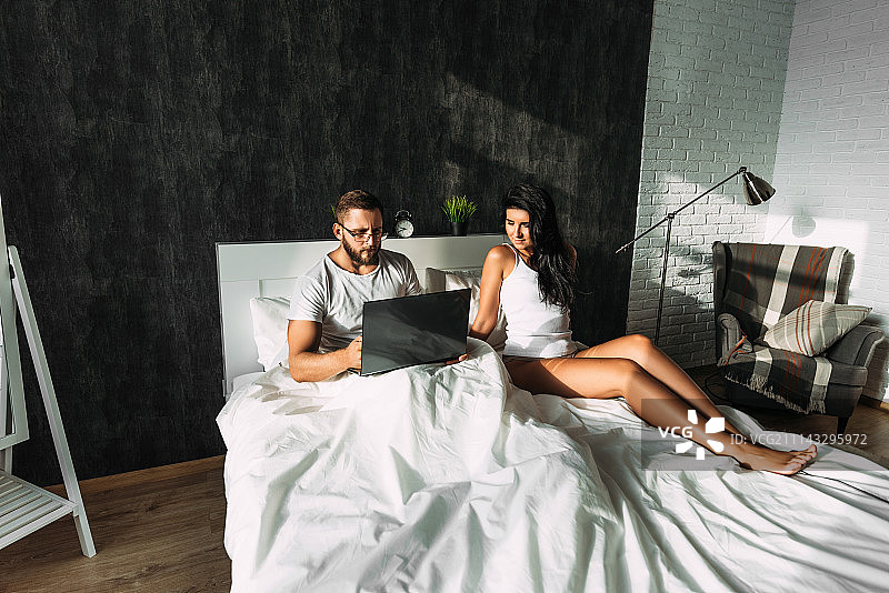 情侣使用笔记本电脑工作图片素材