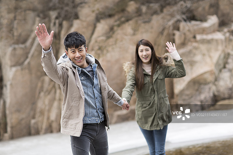 快乐年轻情侣挥手打招呼图片素材