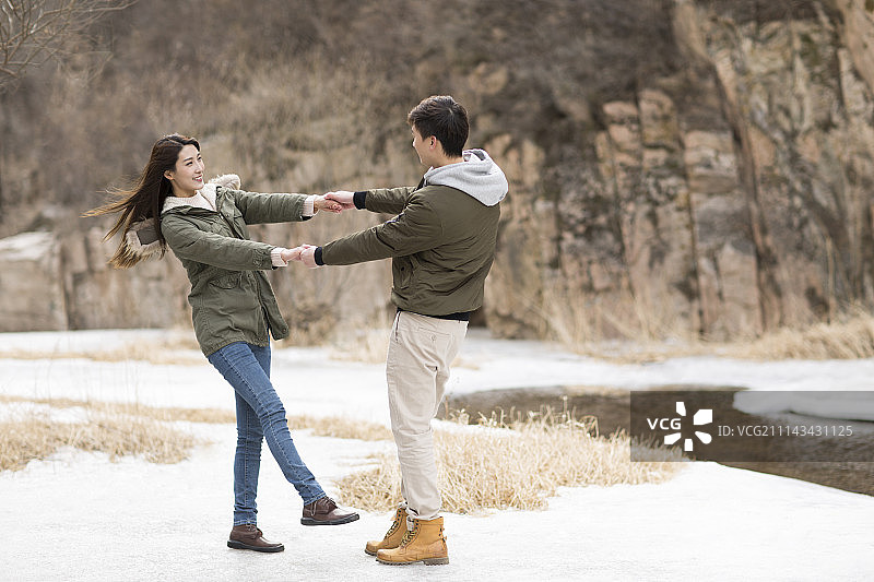 快乐年轻情侣手拉手旋转图片素材