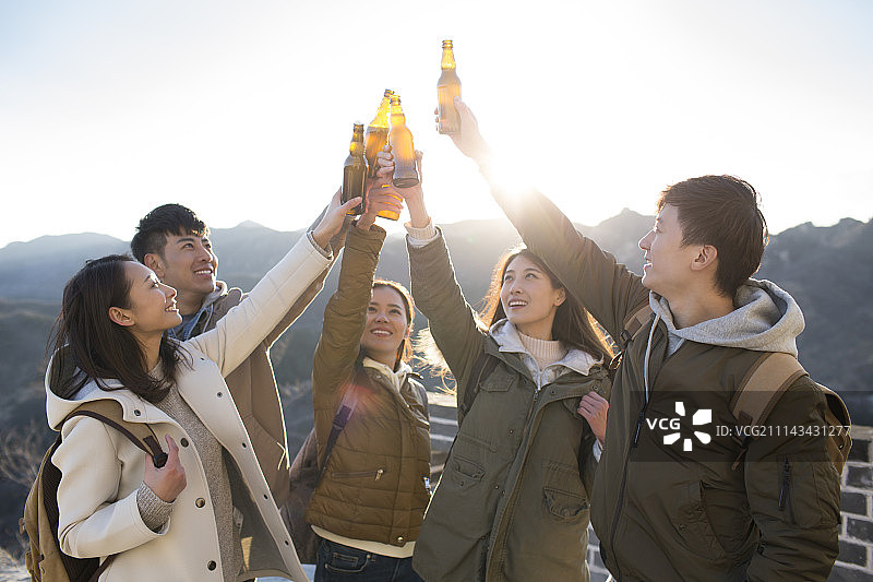 快乐年轻人在长城喝啤酒图片素材