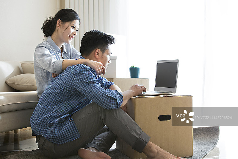 年轻情侣使用笔记本电脑图片素材