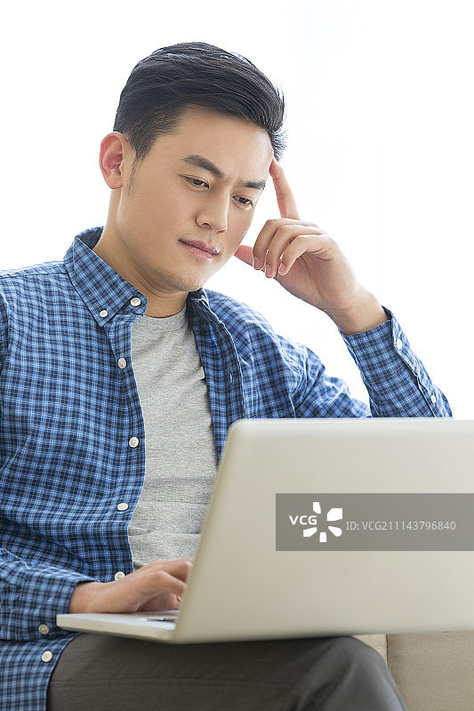 年轻男子使用笔记本电脑图片素材