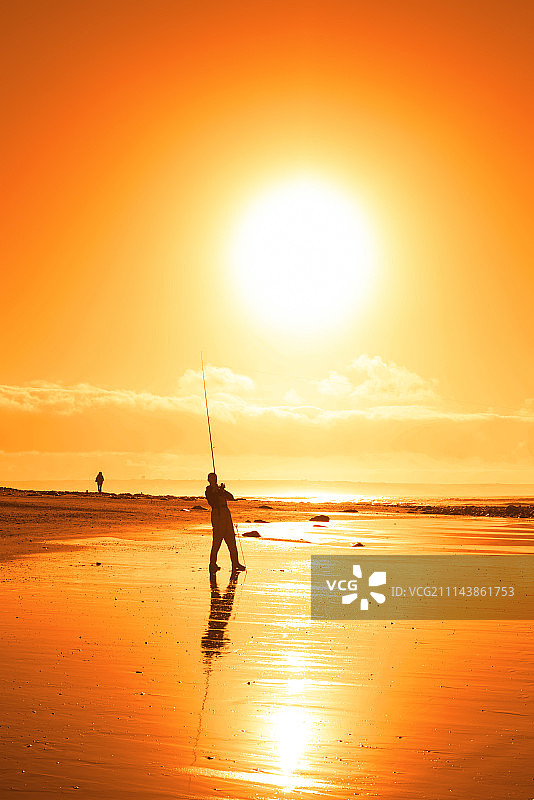 在巴利布尼恩海滩钓鱼的孤独的渔夫图片素材